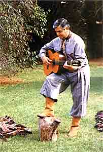 paisano tocando la guitarra en el fogon de la estancia